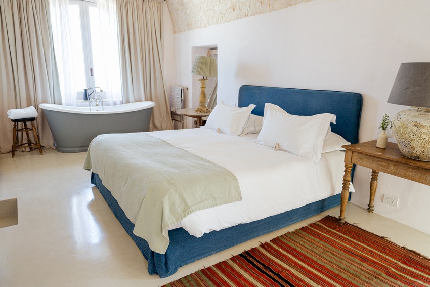 Masseria Petrarolo bedroom with double bed and bathtub