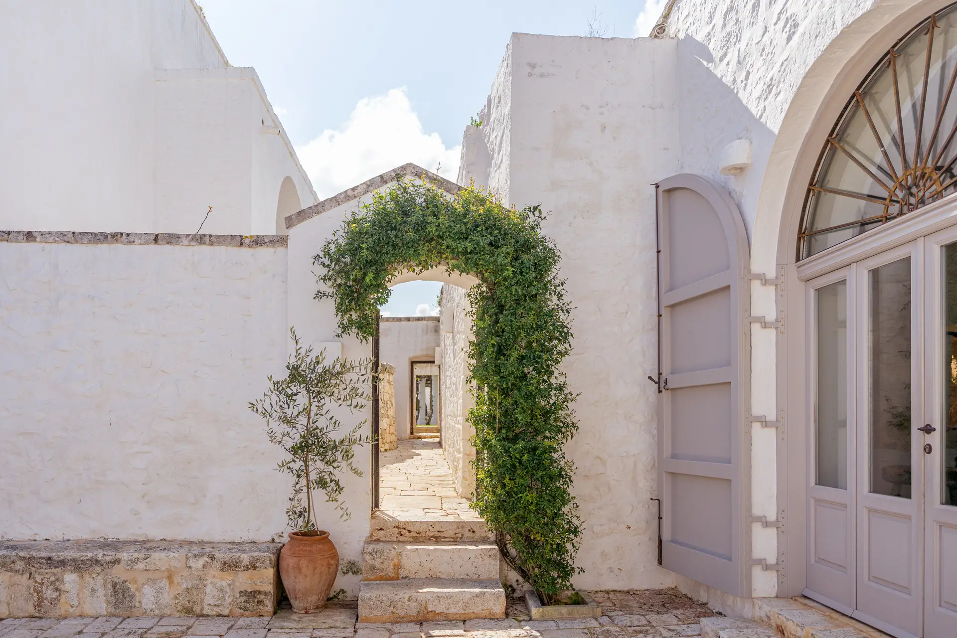 Masseria Petrarolo entrance with stone arch and greenery