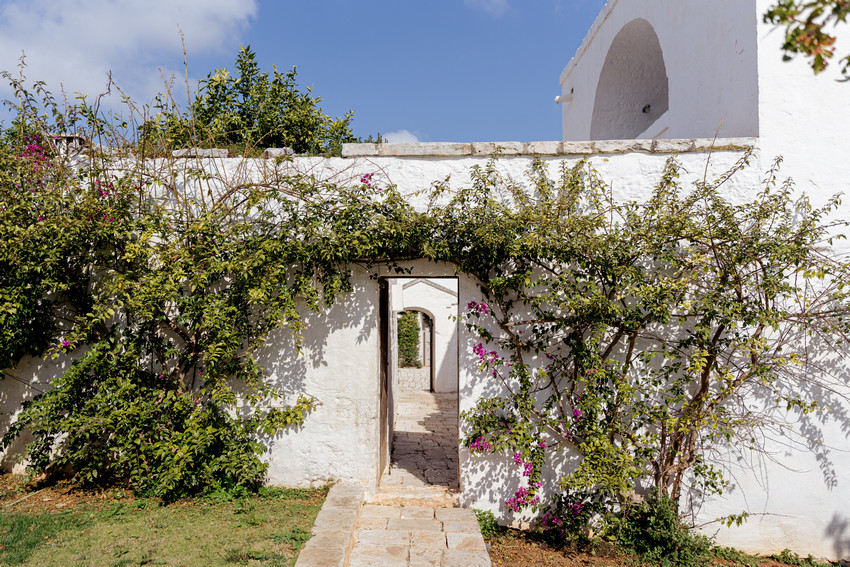 Masseria Petrarolo entrance with stone arch and greenery