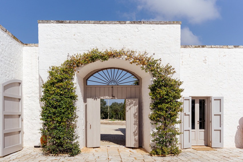 Masseria Petrarolo courtyard with arched doorway and Mediterranean plants
