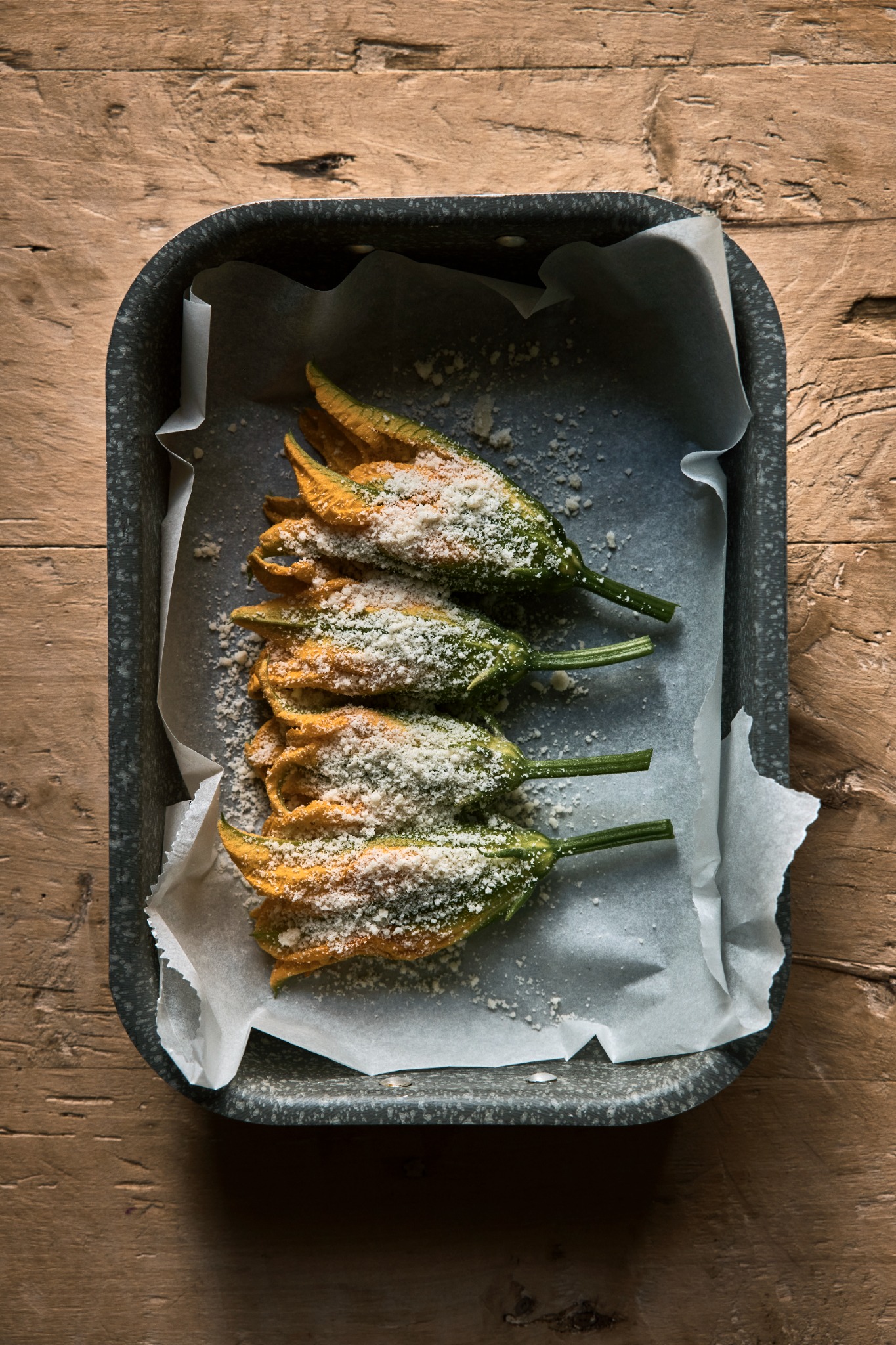 Courgette flowers prepared with a topping of grated cheese