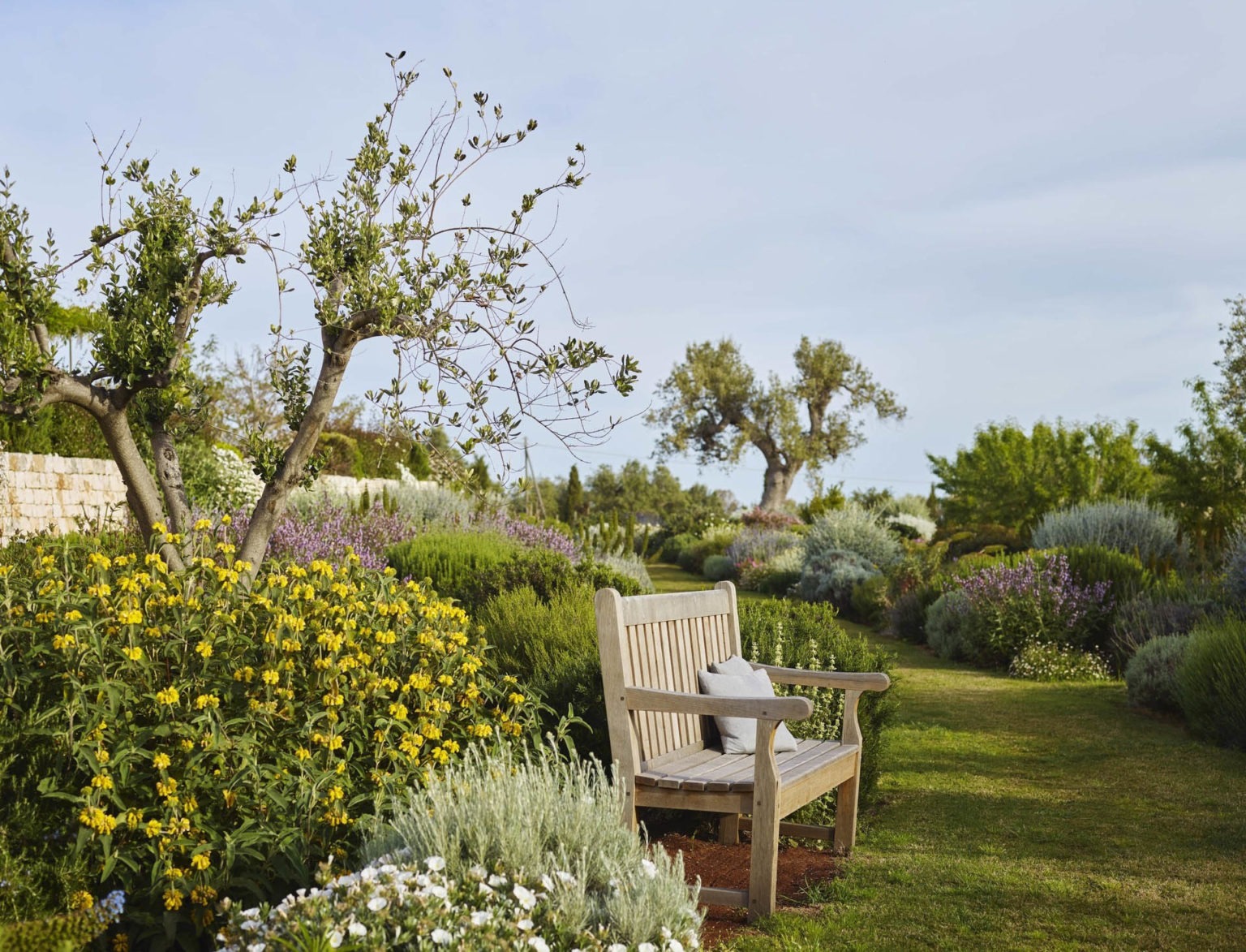 A charming bench in the garden, surrounded by flowers, at Masseria Petrarolo