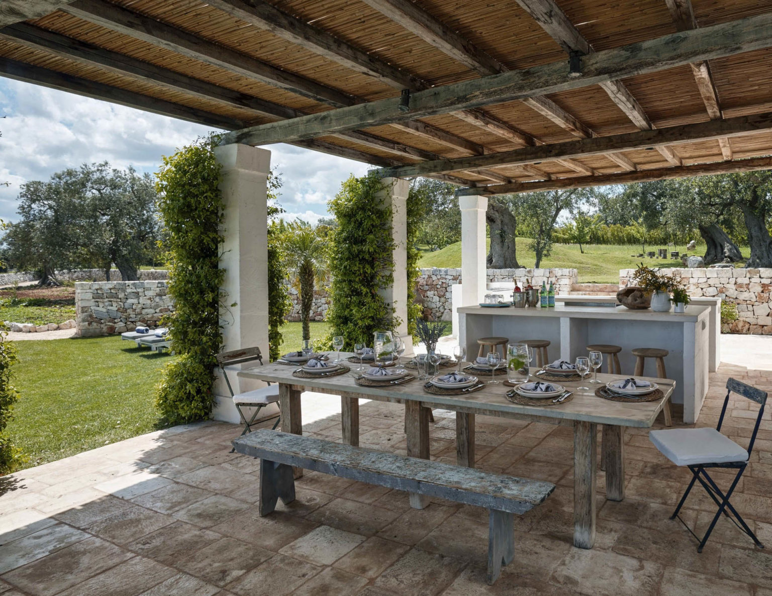 A table set for lunch beneath the poolside pergola