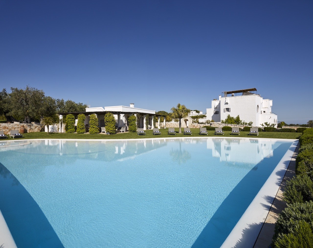 The expansive main garden pool with Masseria Petrarolo beyond